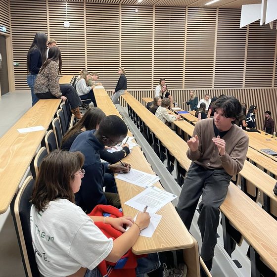 Un bénévole échange avec des étudiants pendant un atelier en amphithéâtre